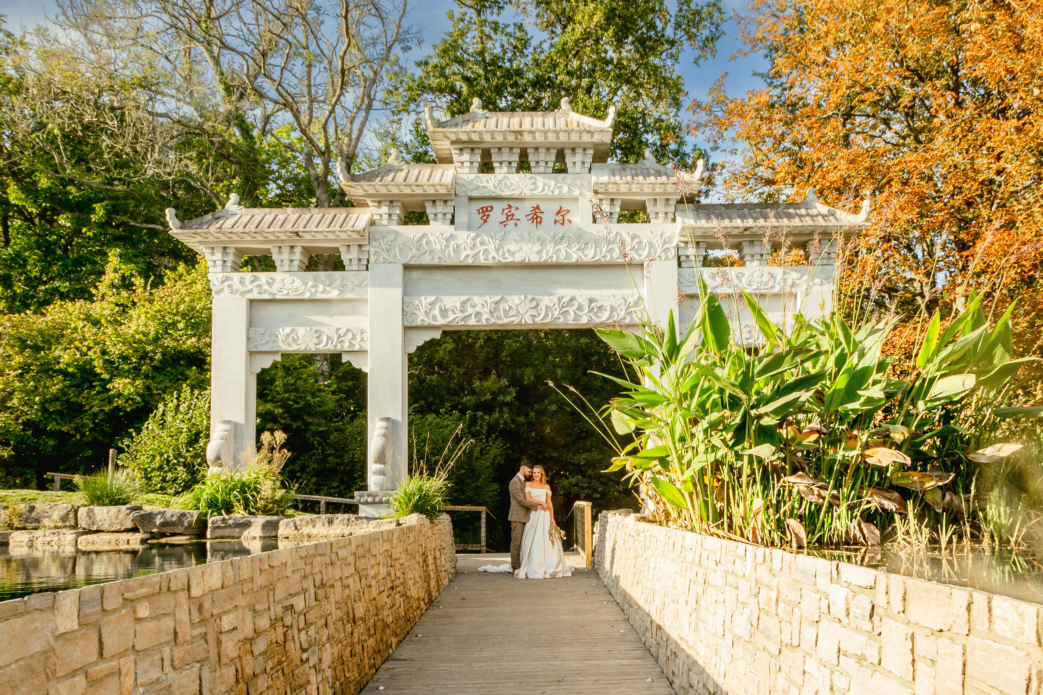 Couple on their wedding standing underneath chinese marble arch