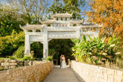Couple on their wedding standing underneath chinese marble arch