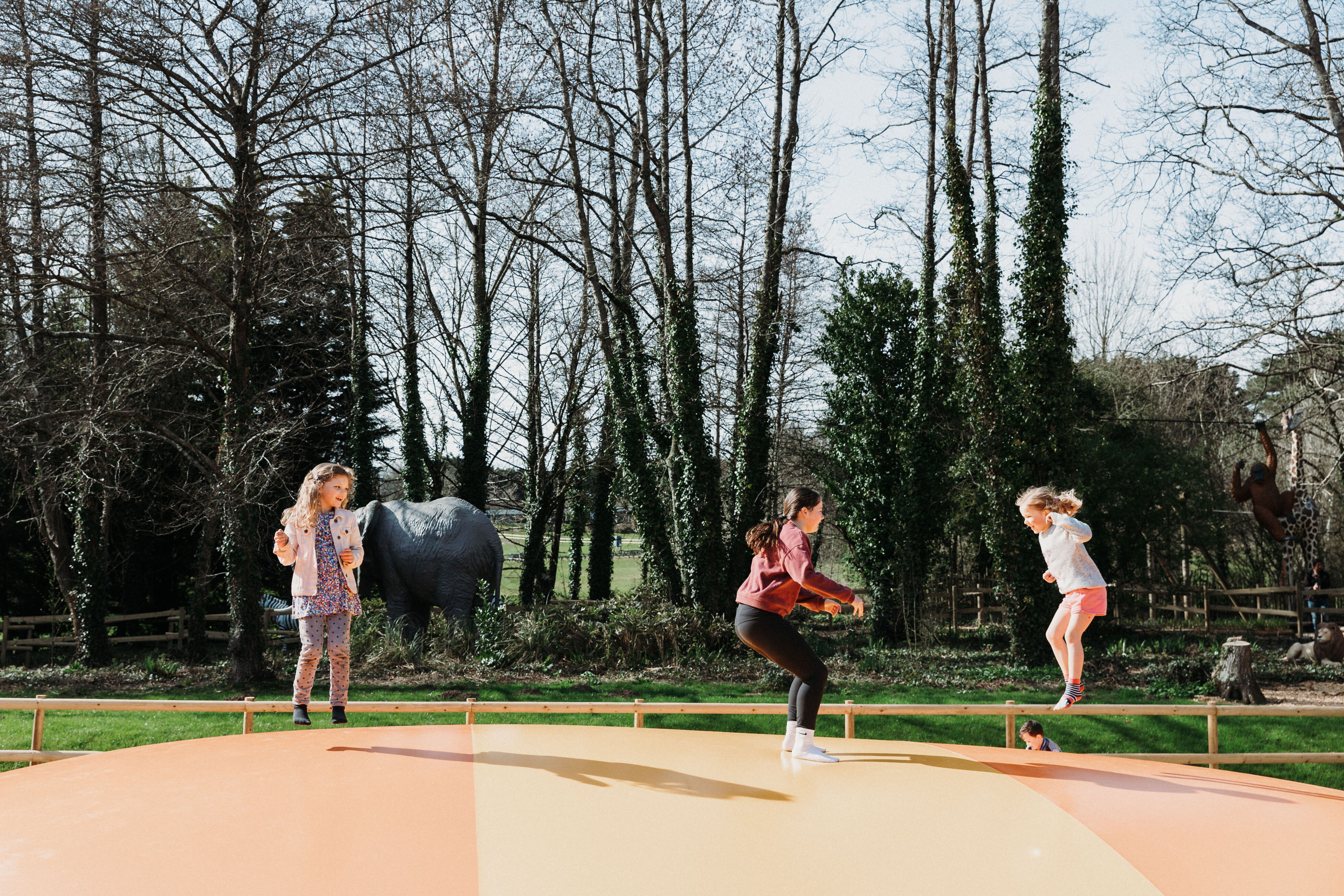Three girls jumping on large bouncy pillow at Robin Hill Adventure Park