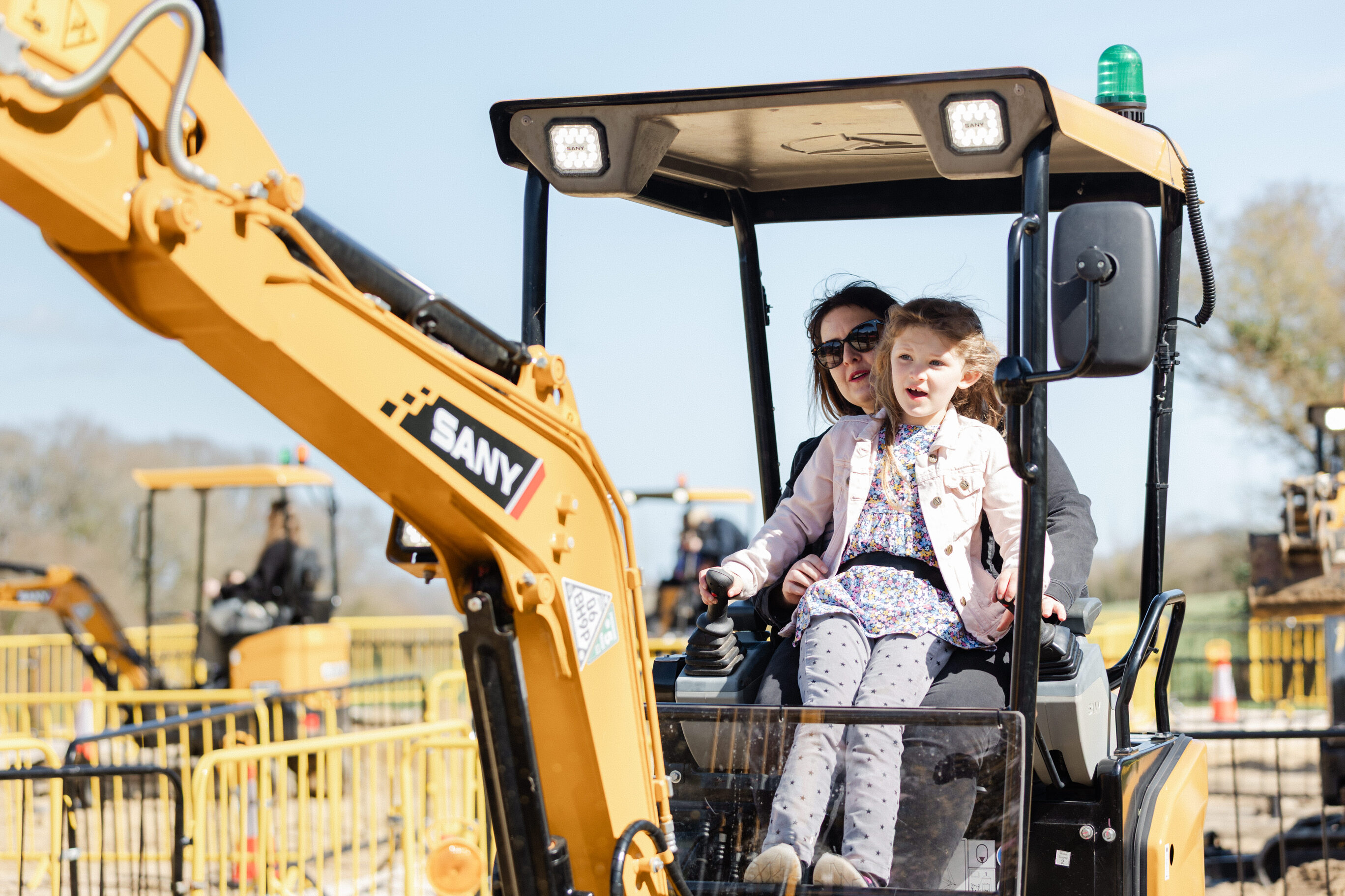 Mother and Daughter playing on toy digger