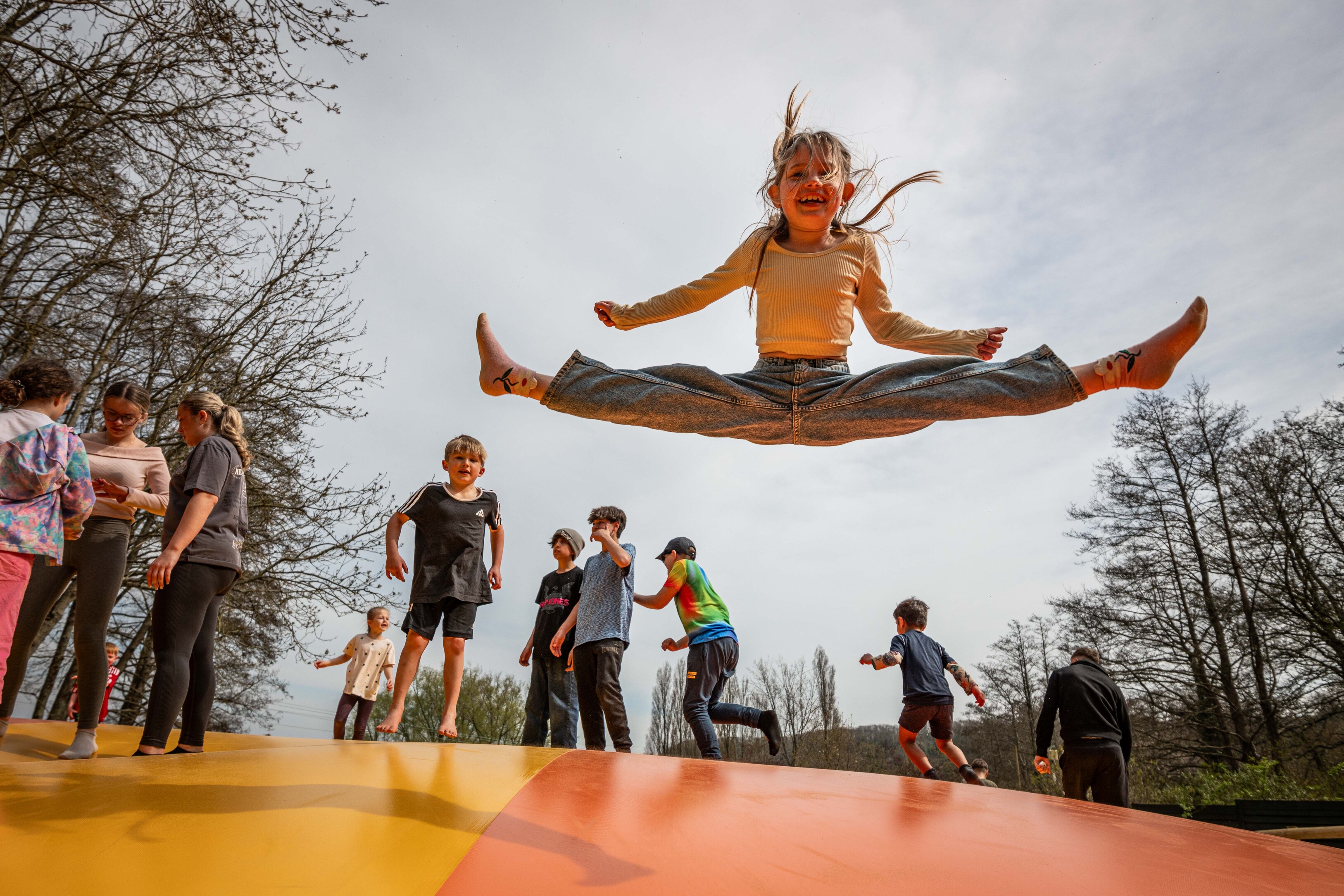 Girl straddle jumping on large inflatable pillow