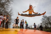 Girl straddle jumping on large inflatable pillow