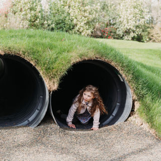 Young girl playing in tunnel 