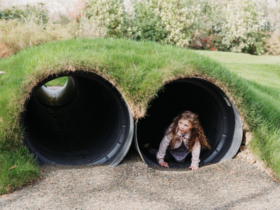 Young girl playing in tunnel 