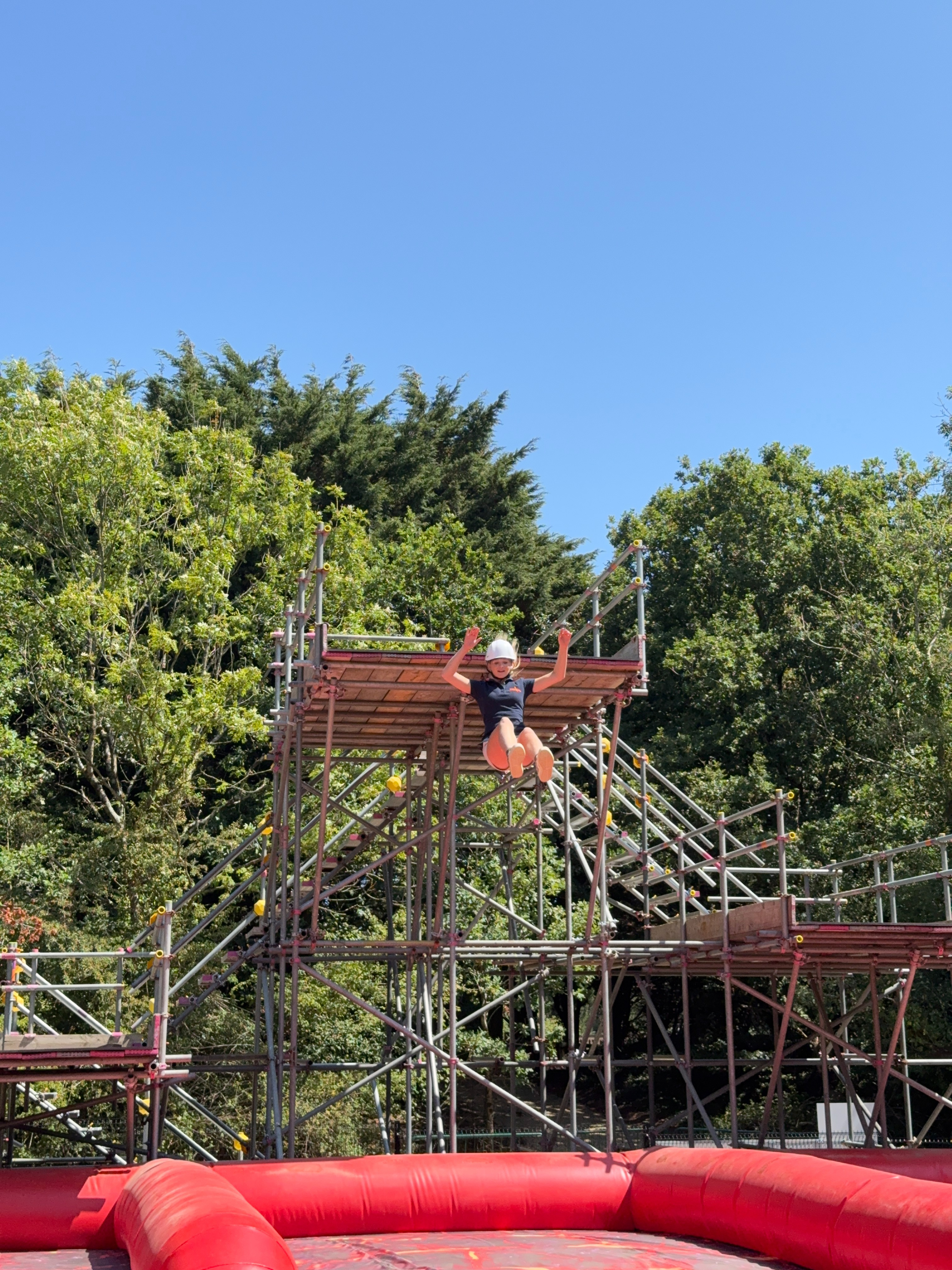 teen girl jumping from platform at adventure park