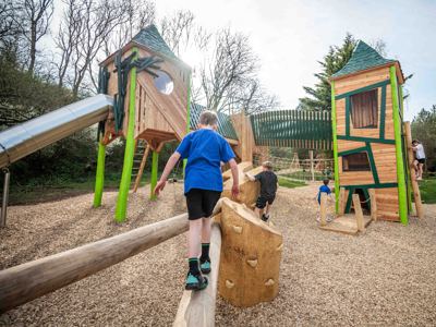 Boy pictured playing on a large wooden play area