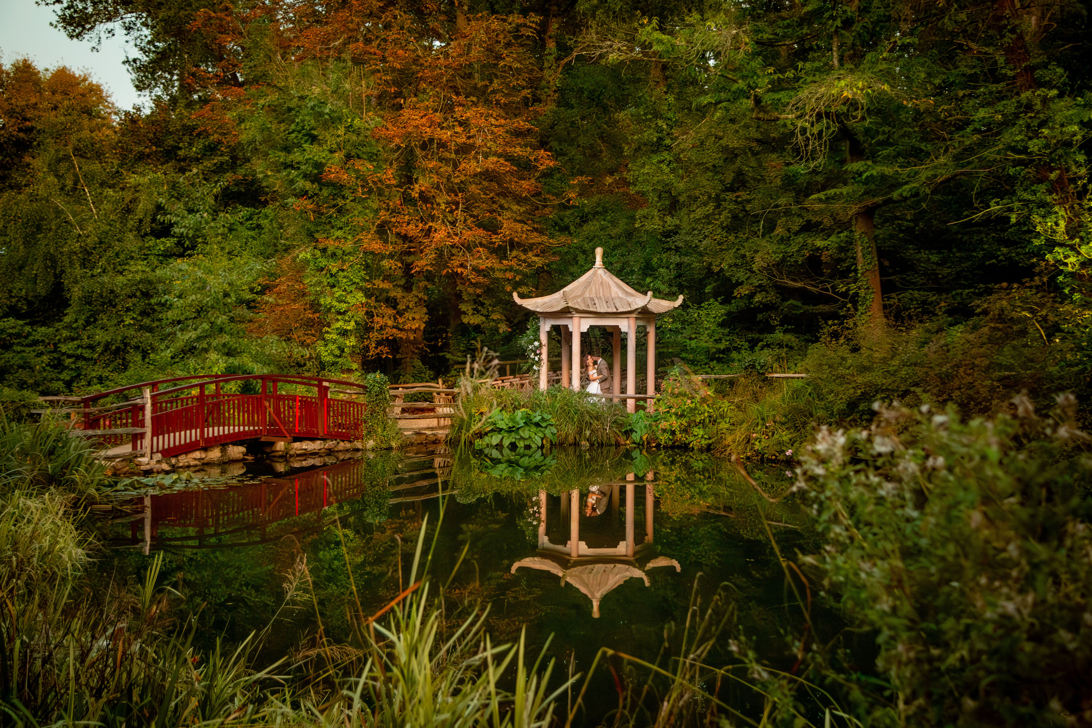 Wedding couple stood under chinese marble pagola