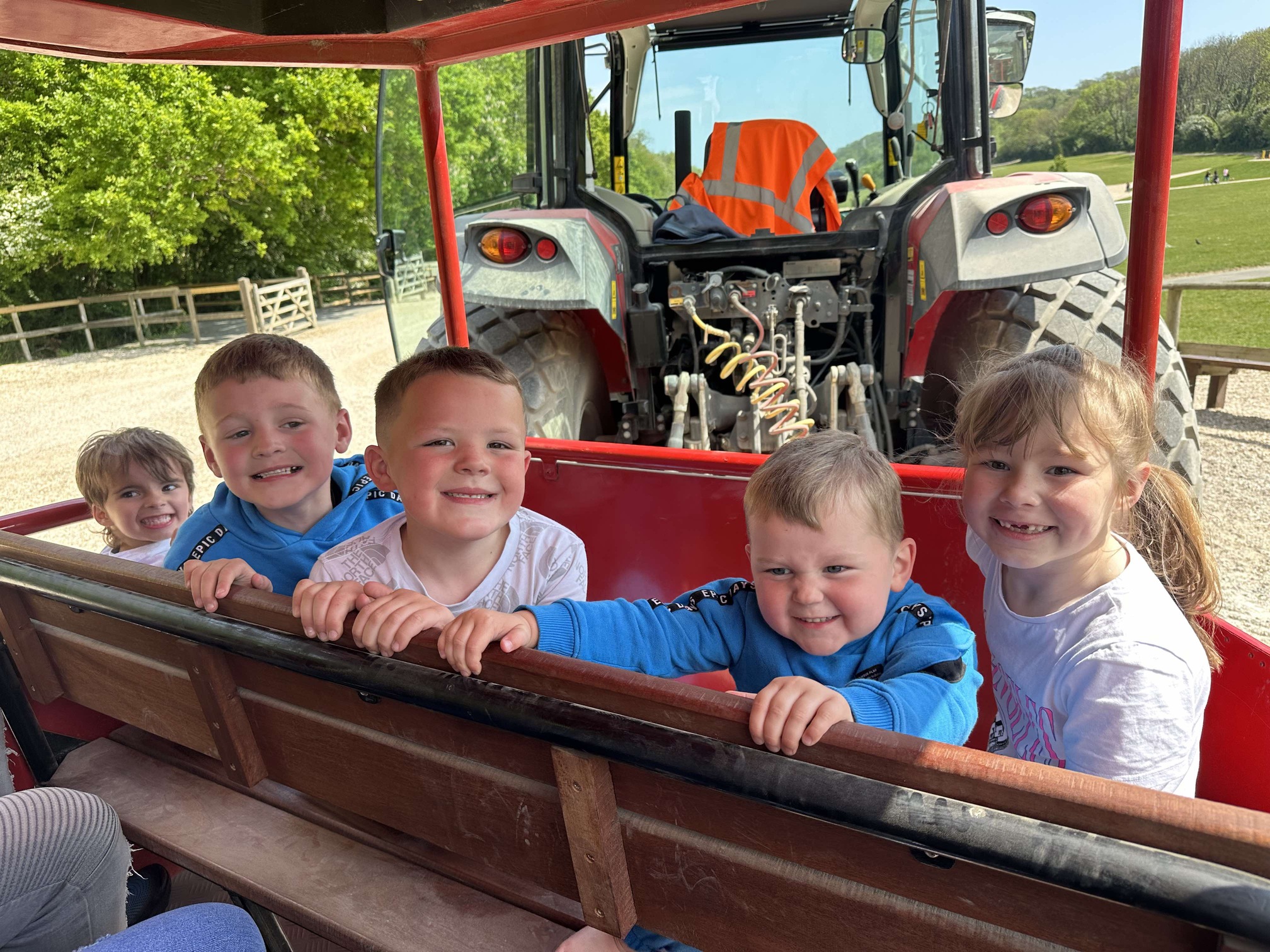 Children smiling whilst riding on harold the tractor