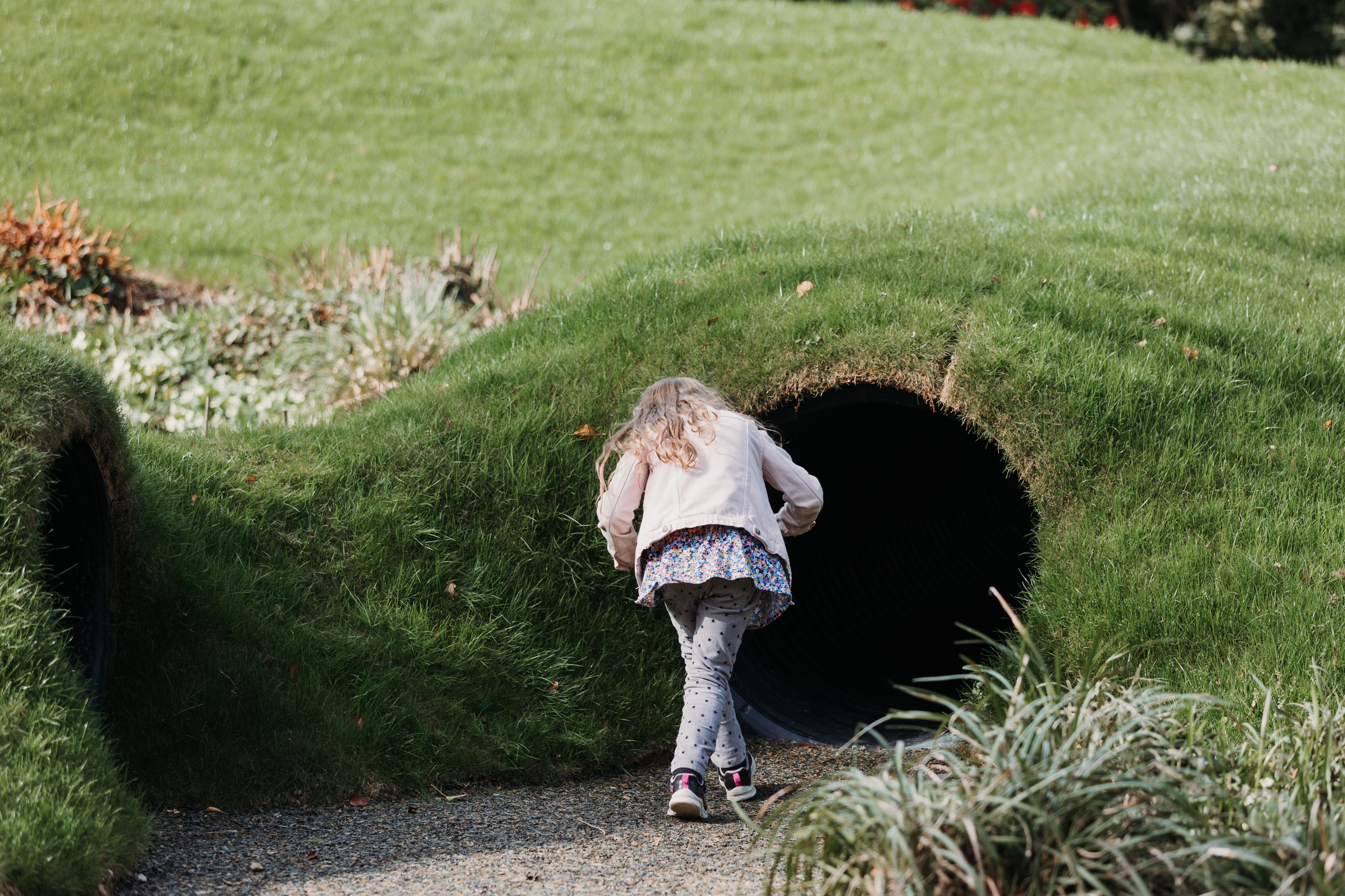 Young girl walking into play tunnels