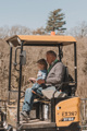 Grandad and Grandson playing on toy digger
