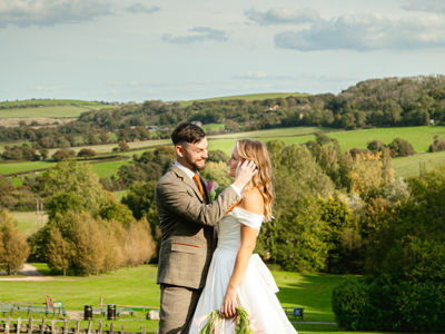 Wedding couple smiling with countryside background and white peacock
