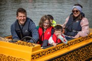 Family on five on a leopard themed electric boat