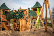 Large wooden play area with child playing on it 