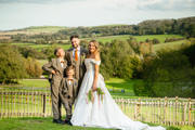 Family photo on their wedding day with countryside background